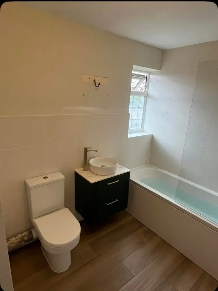 Completed bathroom with toilet, vessel sink vanity and bathtub