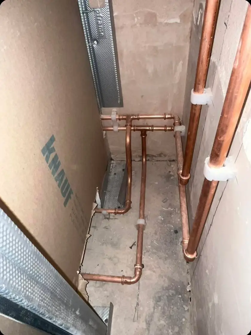Neat copper heating and plumbing first-fix pipework beside plasterboard and metal studs