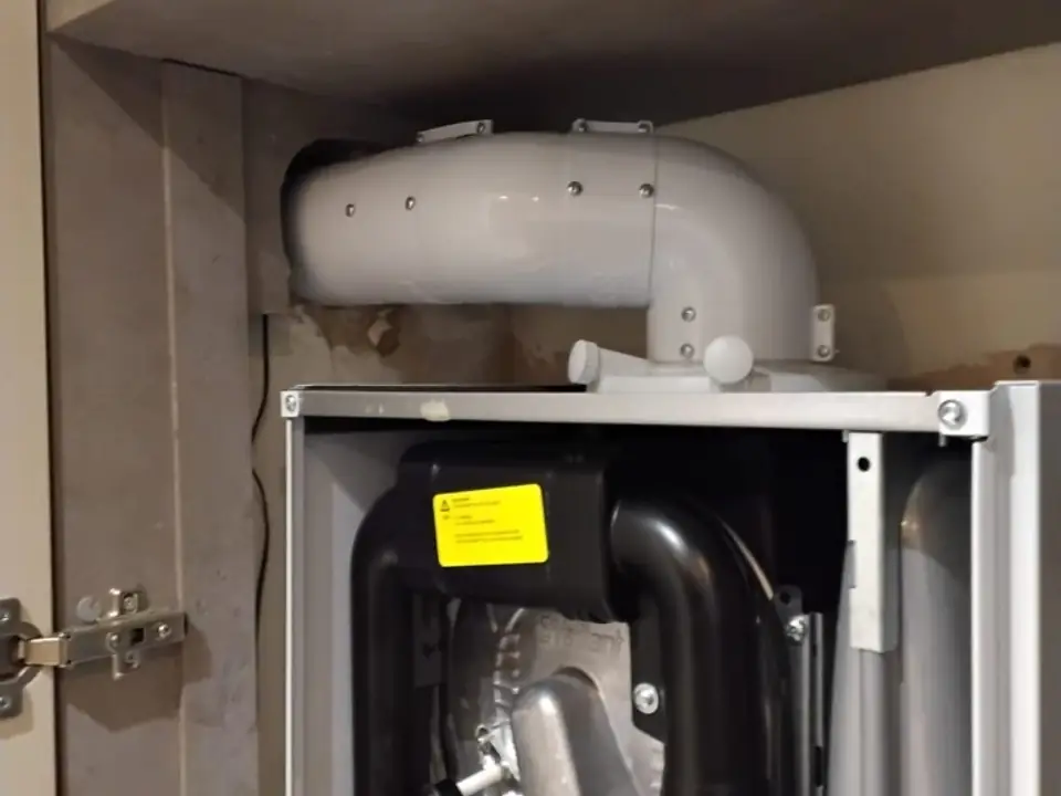 Boiler case open, flue connection exposed during a repair